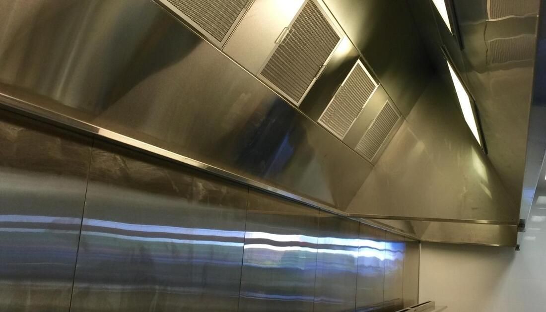 A Stainless Steel Hood Is Hanging from The Ceiling of A Kitchen  — Townsville Stainless Steel in Garbutt, QLD