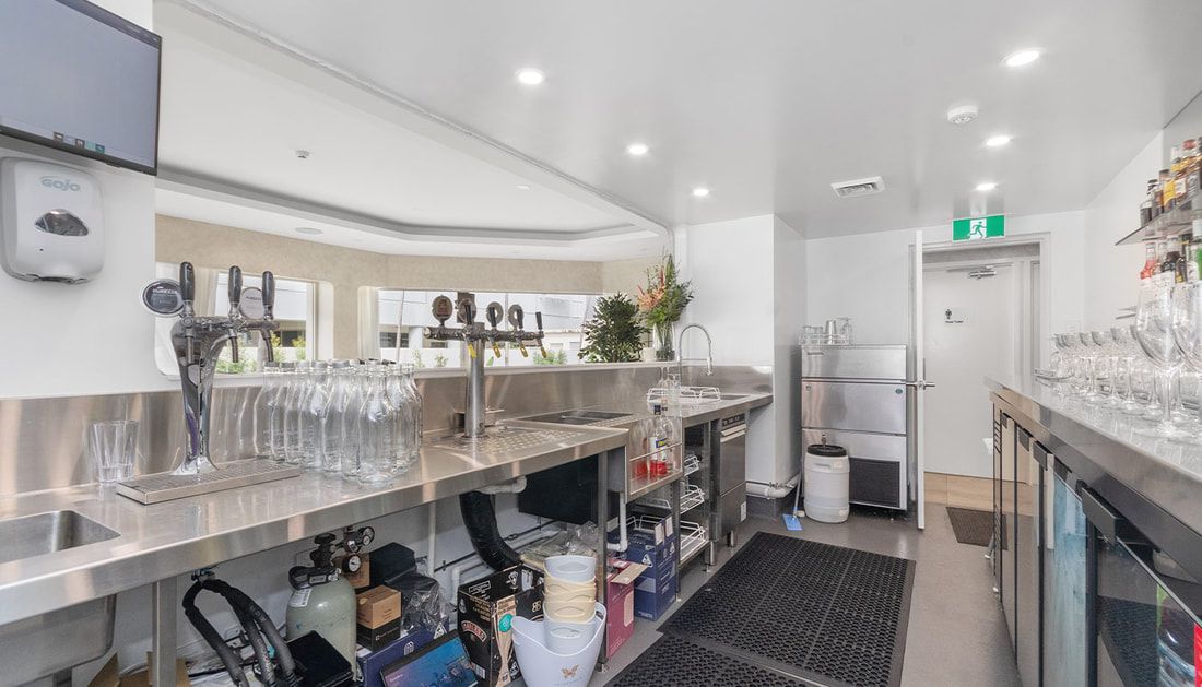A Kitchen with A Lot of Glasses on The Counter and A Refrigerator — Townsville Stainless Steel in Mount Isa, QLD