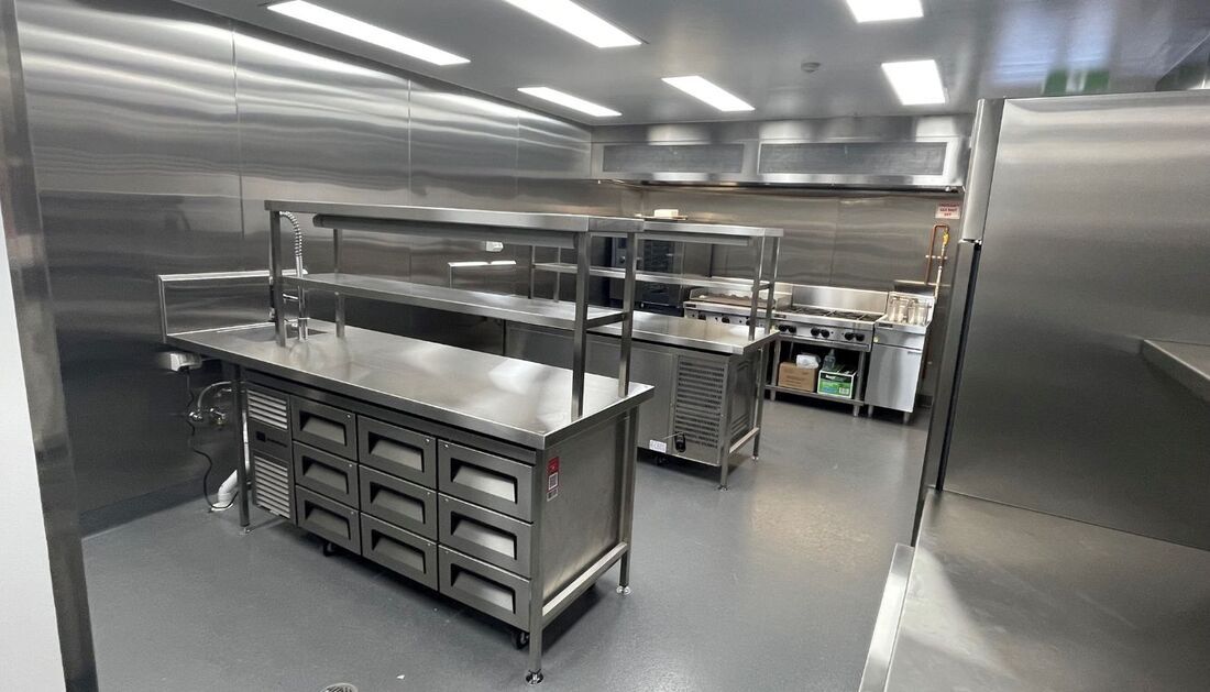 A Large Kitchen with Stainless Steel Appliances and Shelves — Townsville Stainless Steel in Garbutt, QLD