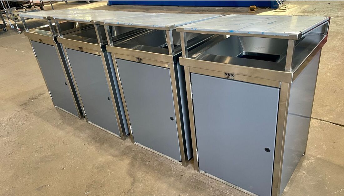 A Row of Stainless Steel Trash Cans Sitting on Top of A Table — Townsville Stainless Steel in Garbutt, QLD A Row of Stainless Steel Trash Cans Sitting on Top of A Table — Townsville Stainless Steel in Garbutt, QLD