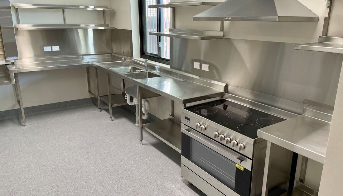 A Kitchen with Stainless Steel Appliances and A Stove — Townsville Stainless Steel in Garbutt, QLD A Kitchen with Stainless Steel Appliances and A Stove — Townsville Stainless Steel in Garbutt, QLD