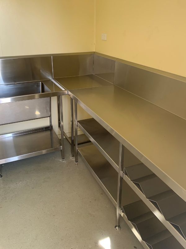 A Kitchen with Stainless Steel Counter Tops and Shelves — Townsville Stainless Steel in Garbutt, QLD A Kitchen with Stainless Steel Counter Tops and Shelves — Townsville Stainless Steel in Garbutt, QLD