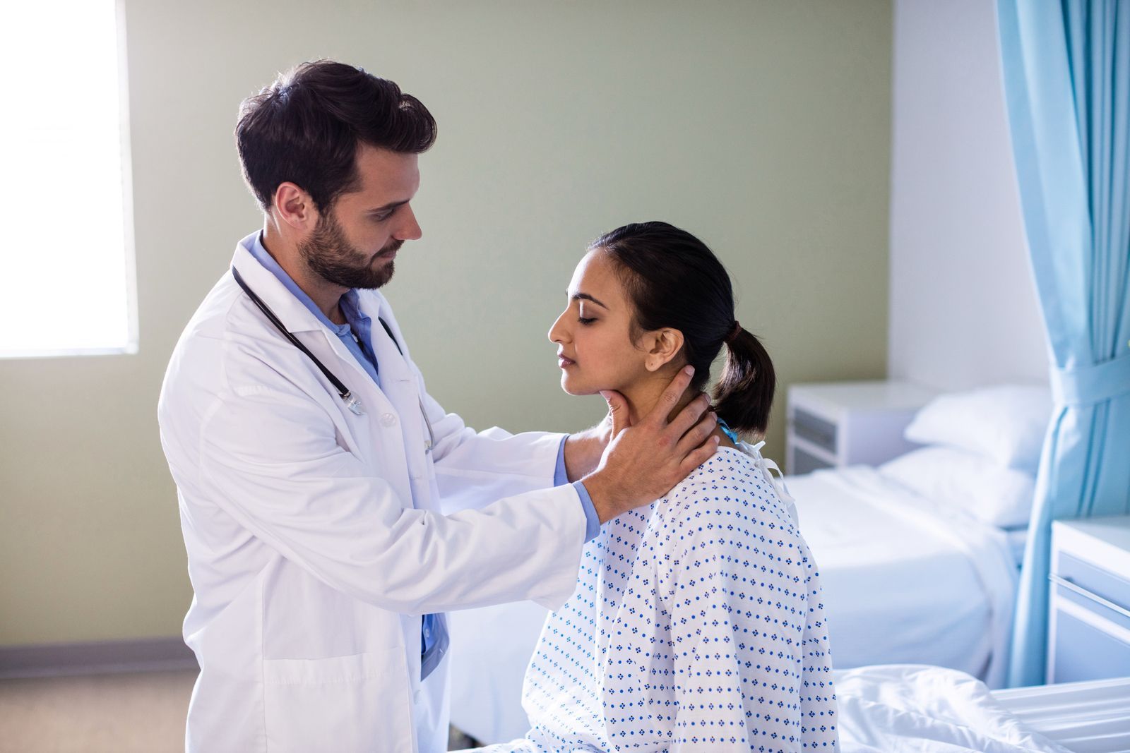 A doctor is examining an older woman 's thyroid gland.