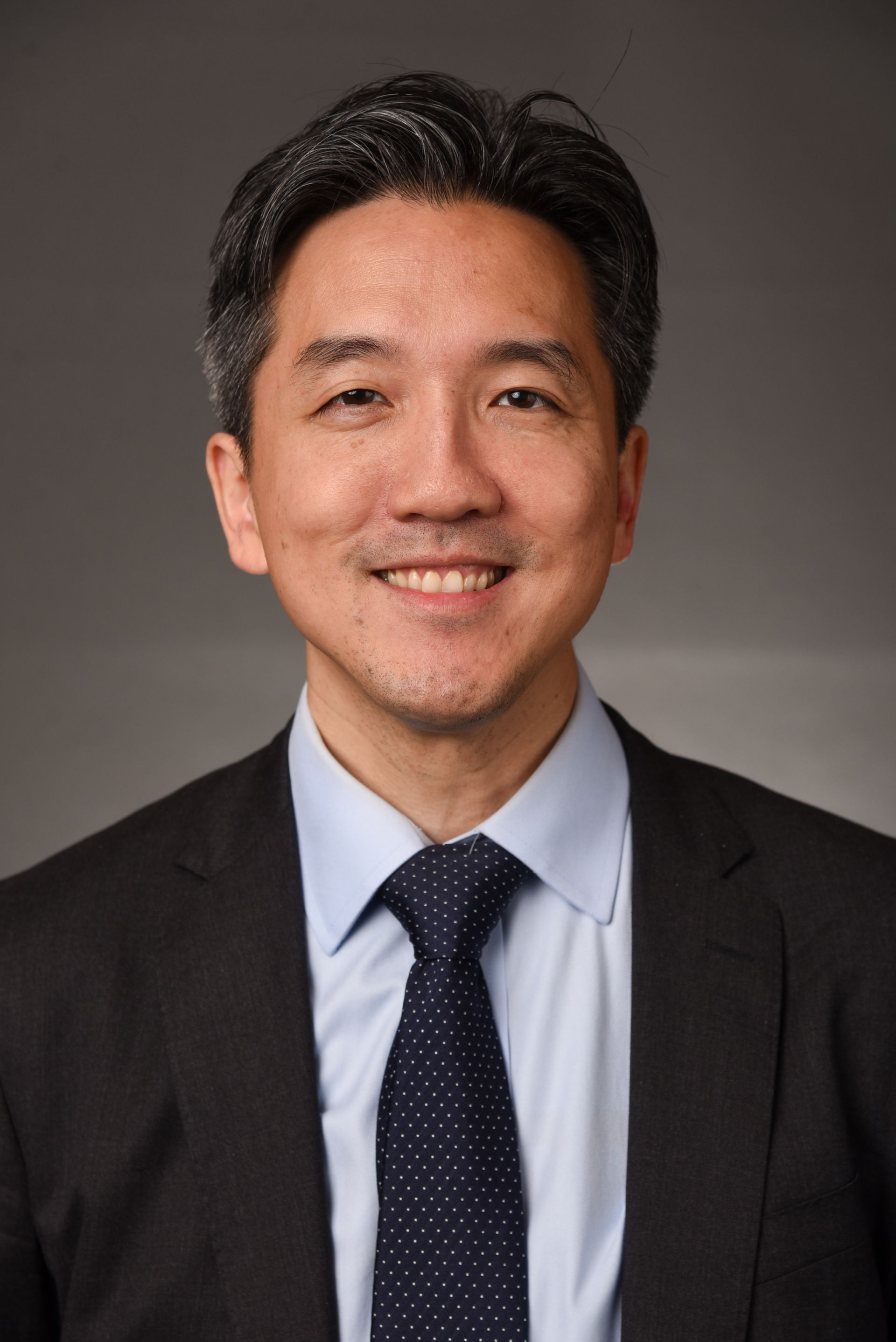 A man in a suit and tie is smiling for the camera.