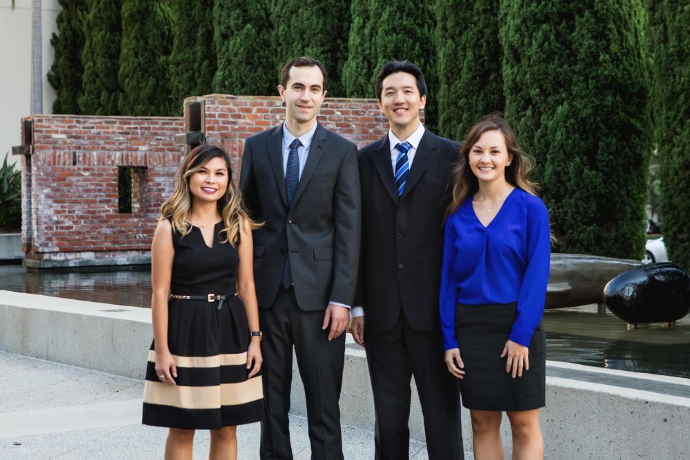 A group of people in suits and ties are posing for a picture.