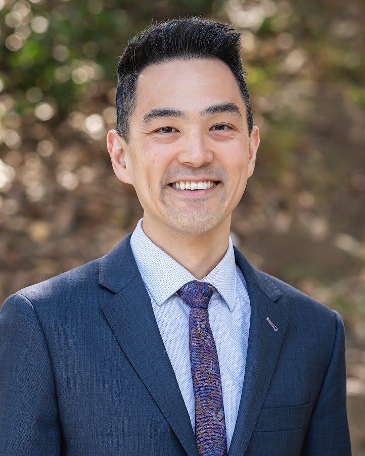 A man in a suit and tie is smiling for the camera.