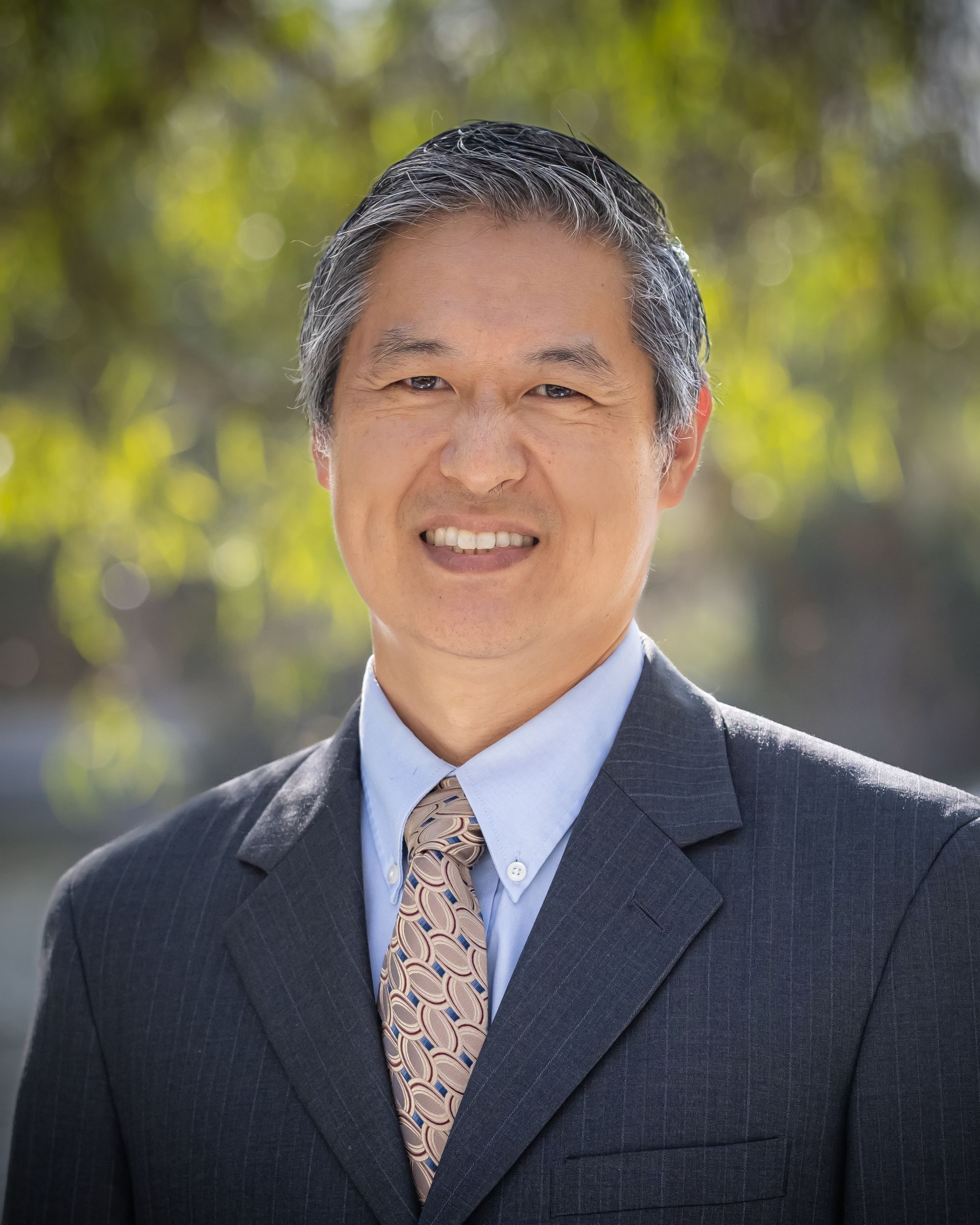 A man in a suit and tie is smiling for the camera.