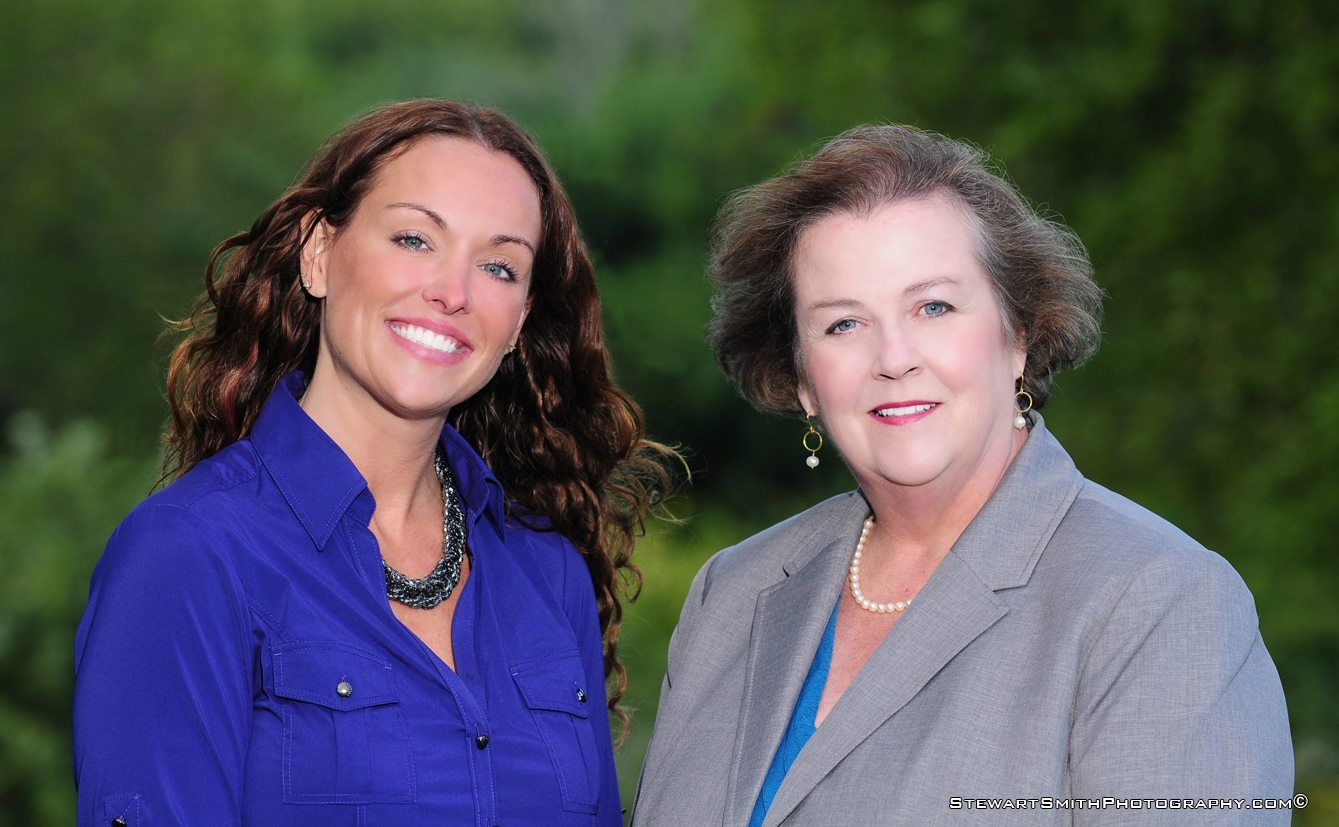 Two women are standing next to each other and smiling for the camera.