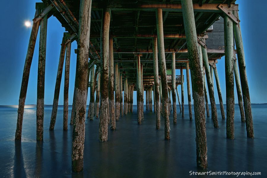 A pier with a full moon in the background