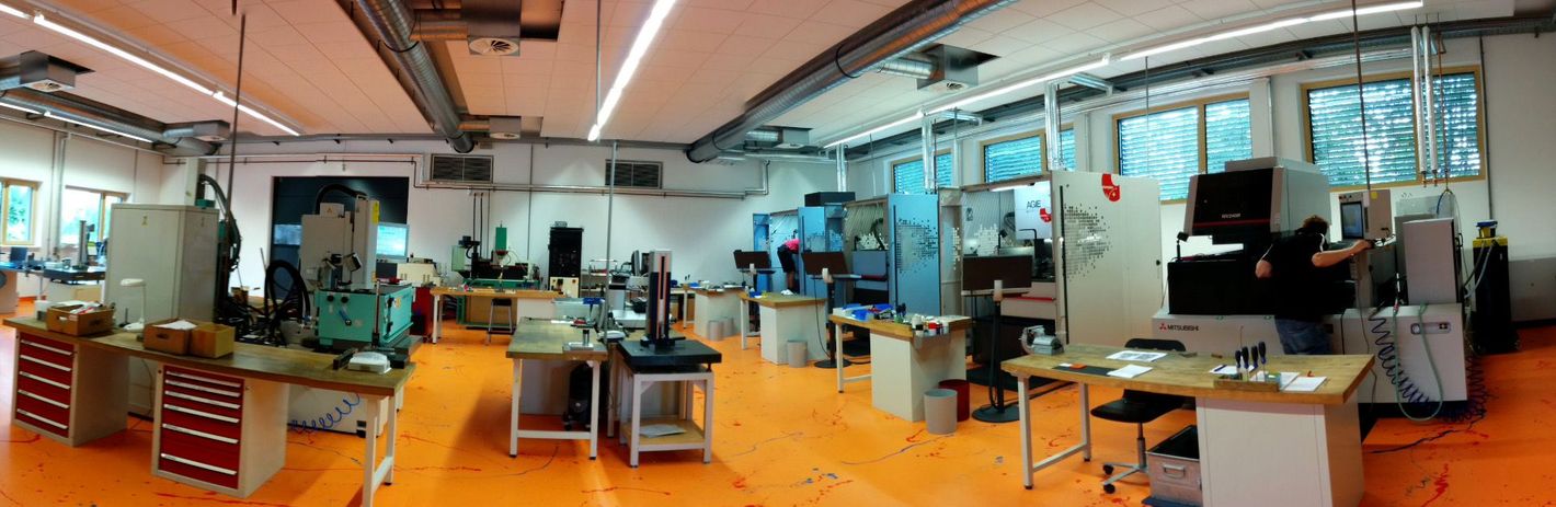 Ein großer Raum mit vielen Tischen und Stühlen in einer Fabrik.