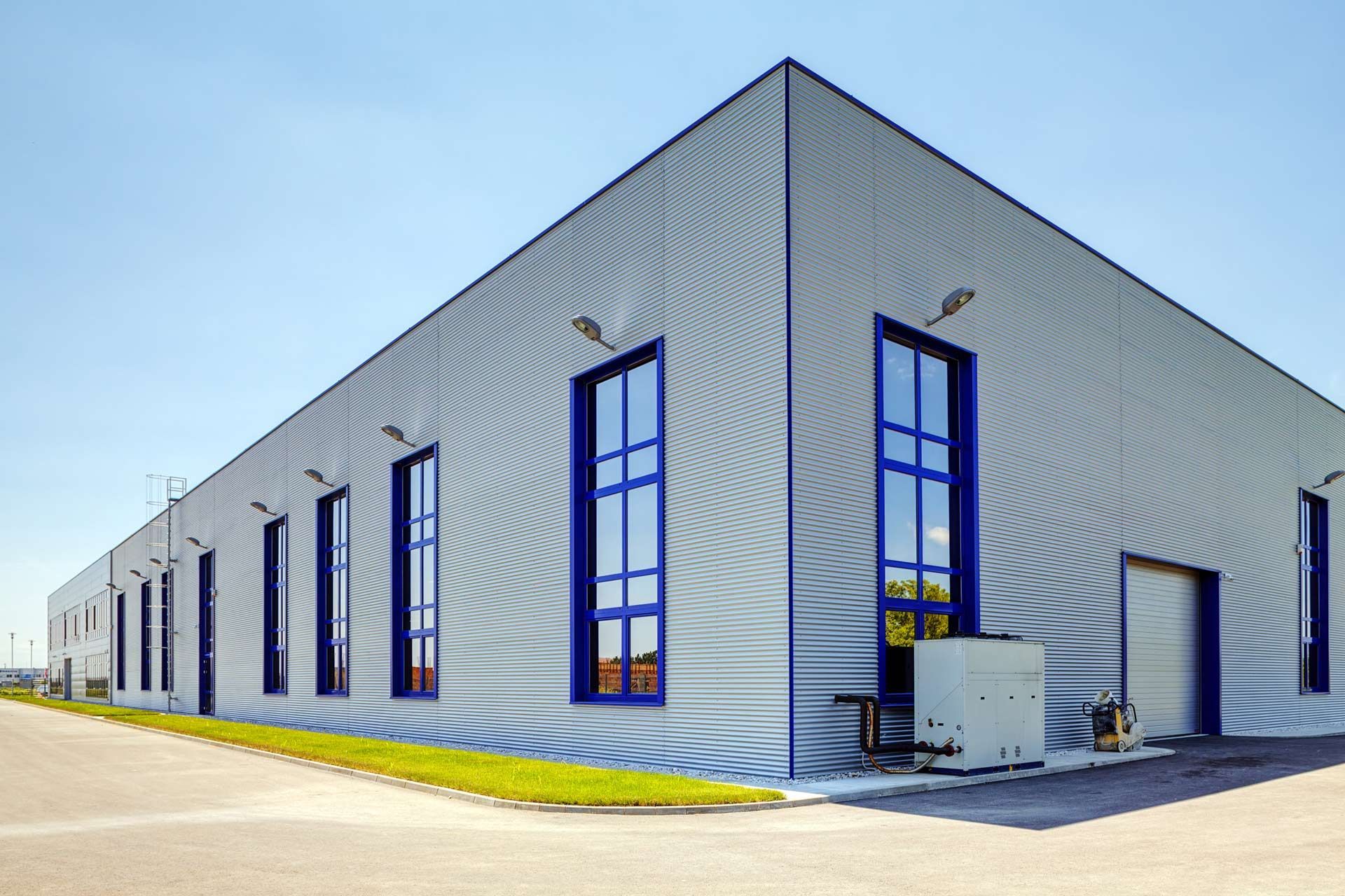 A large building with blue windows and a blue sky in the background.