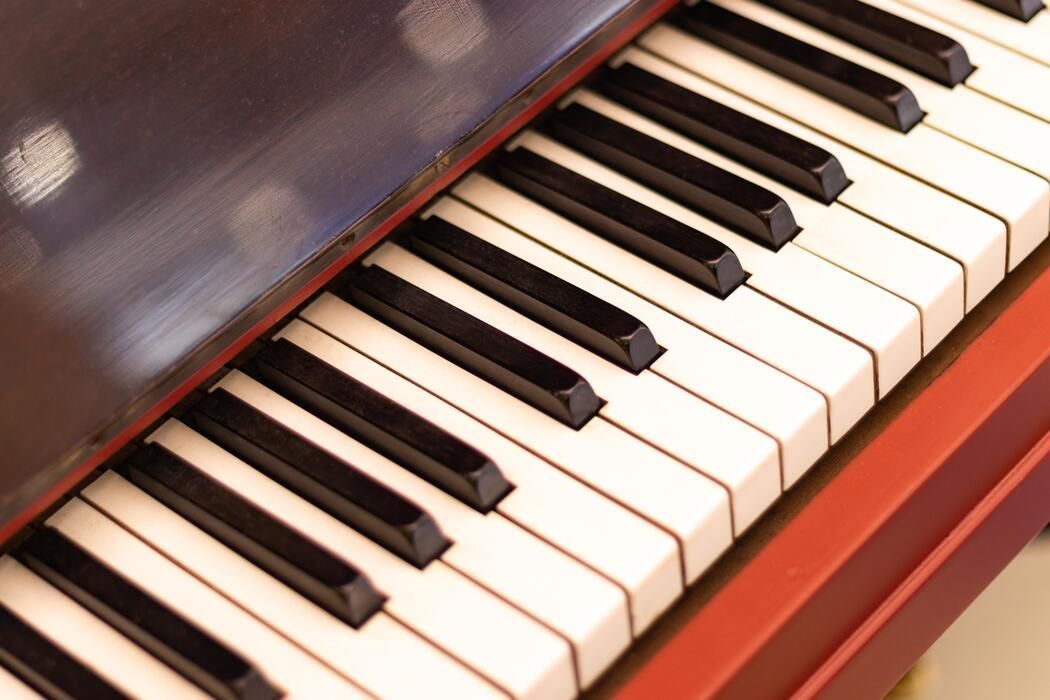 Close-up of a piano keyboard with black and white keys and a dark wood body.