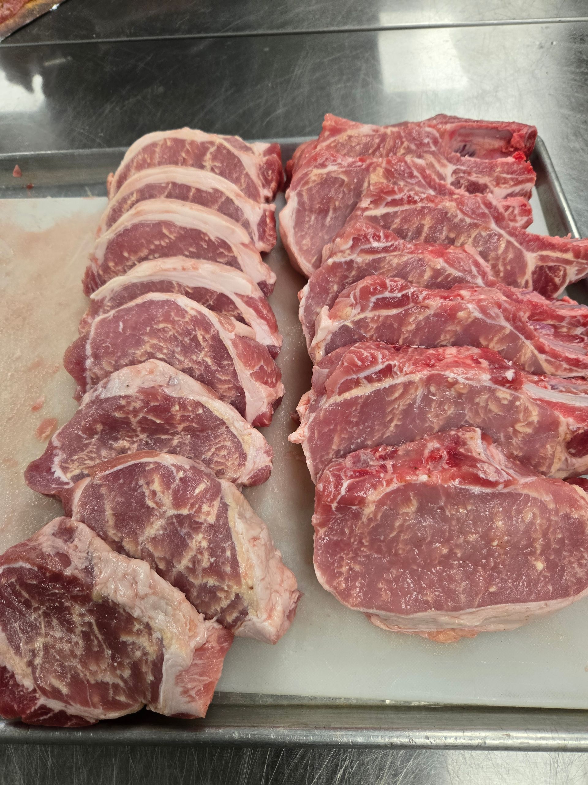 A tray of raw meat is sitting on a table.