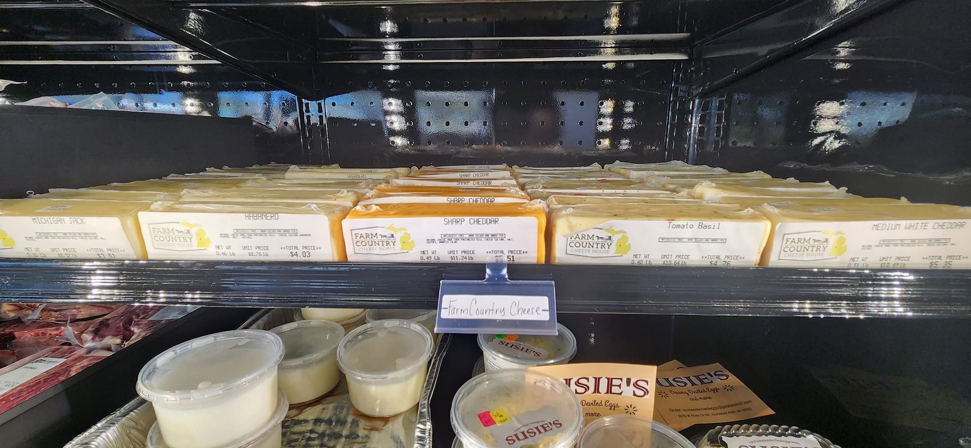 A refrigerator filled with a variety of foods including cheese and yogurt.