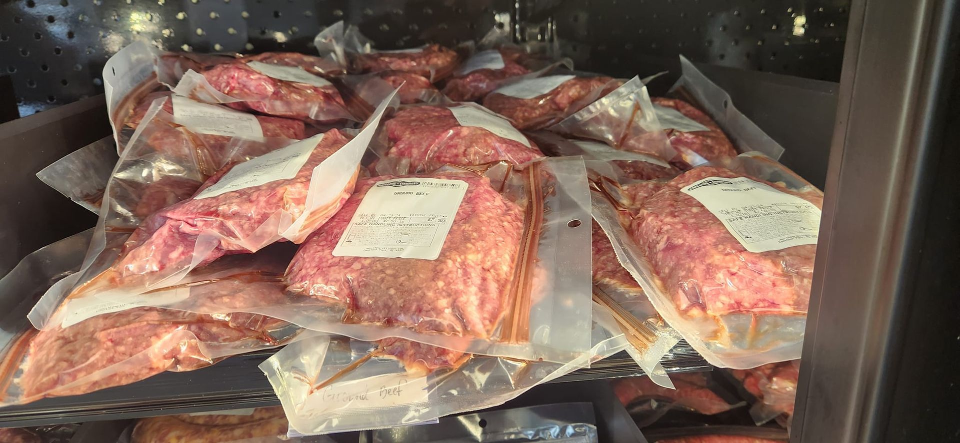 A pile of meat is sitting in a refrigerator.