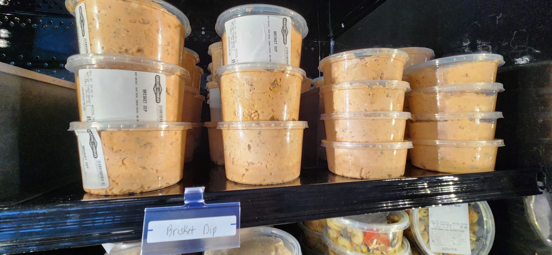 A shelf filled with plastic containers filled with food.