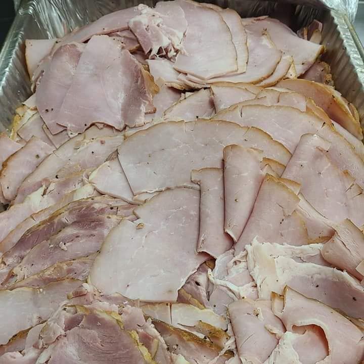 A tray of sliced ham is sitting on a table