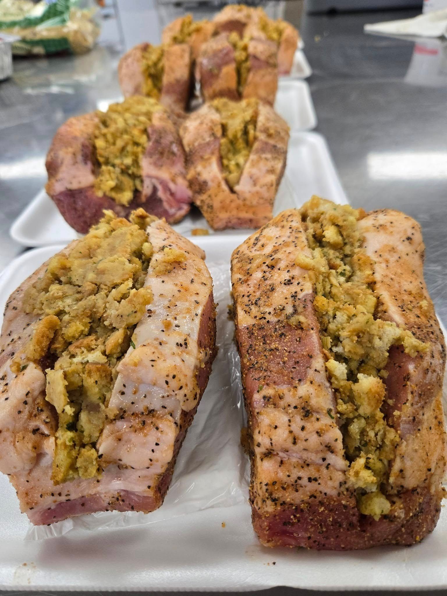 Two pieces of meat are sitting on a styrofoam tray on a table.
