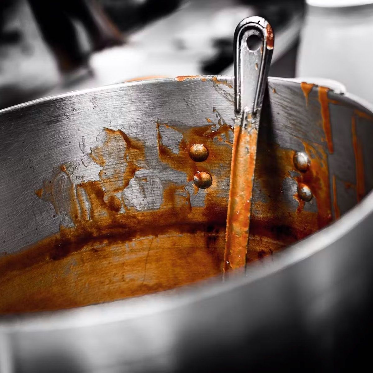 A pot of sauce with a spoon in it