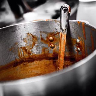 A pot of sauce with a spoon in it