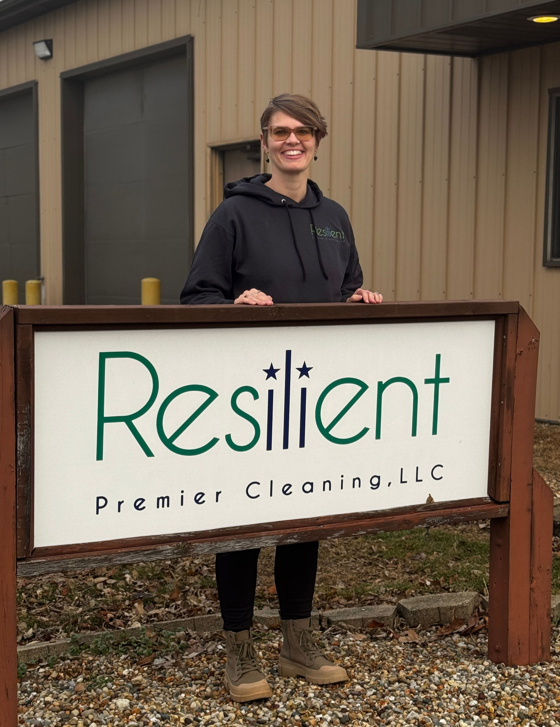 Woman standing behind a sign that reads