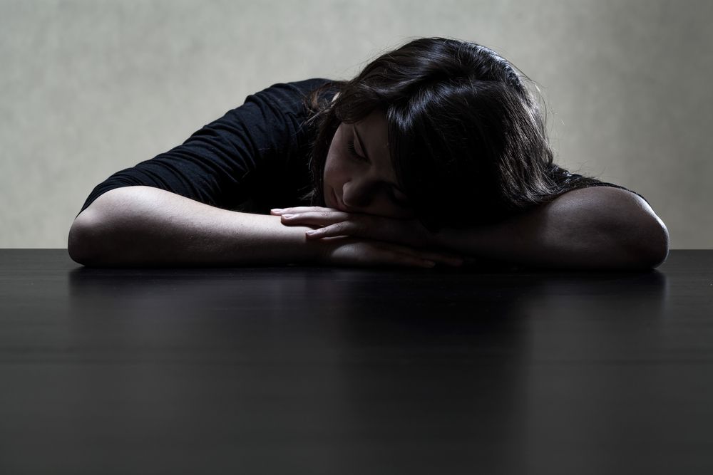 Pensive+and+sad+girl+putting+her+head+on+the+table +horizontal 1
