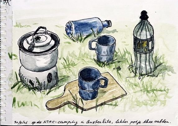 Campingbrandertje en bekers op het gras: een pot, een blikje, een blauwe mok en een plastic fles.