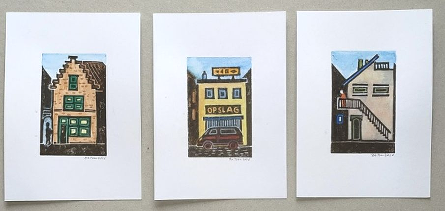 Drie kleine linoprints van kleurrijke gebouwgevels naast elkaar op een witte achtergrond.