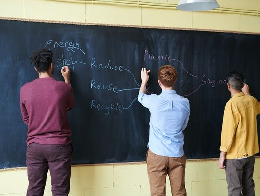 Montessori students writing on a blackboard