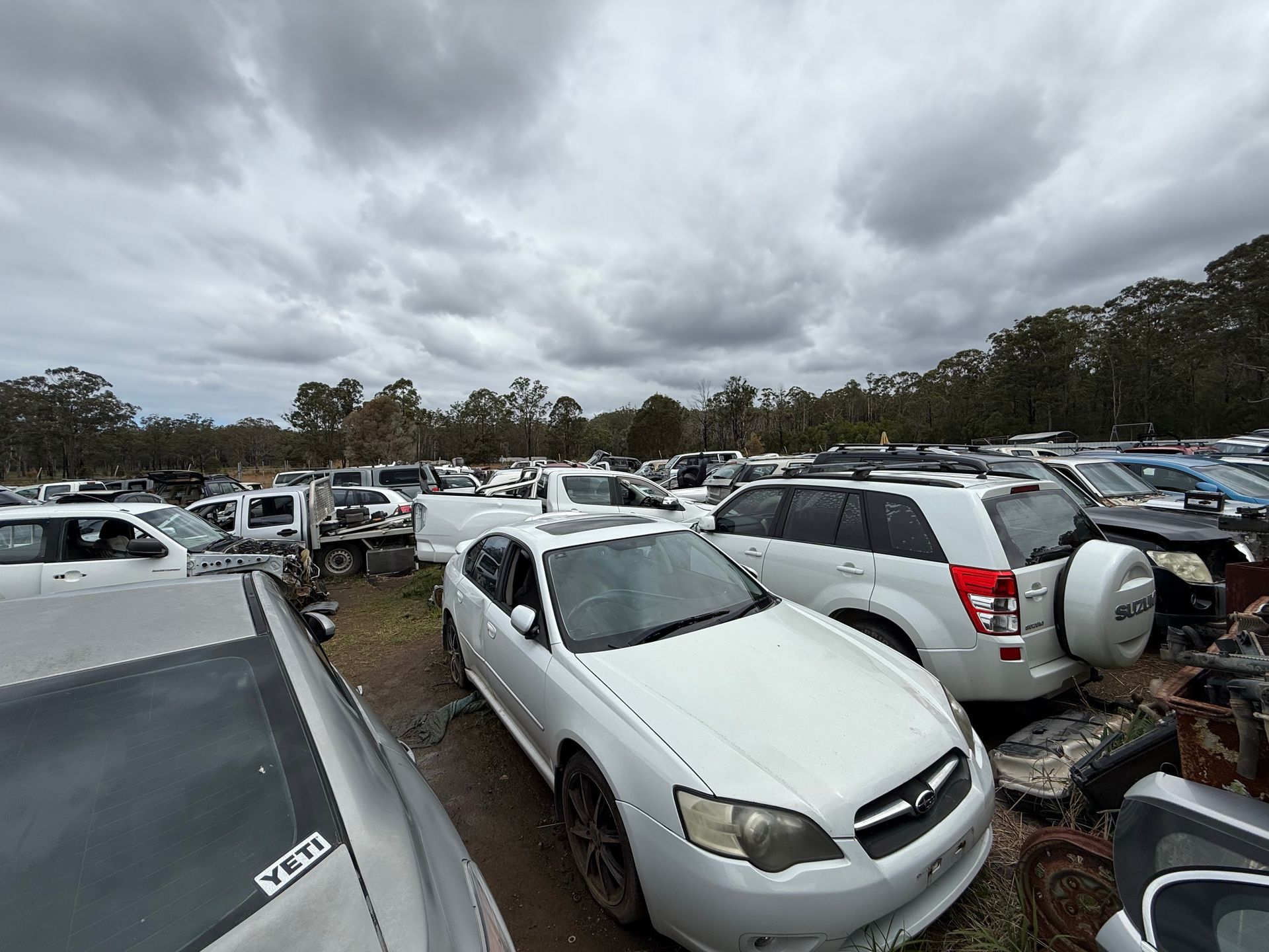 A Red Car On Top Of A Blue Car On Top Of A Green Car Getting Crushed — Old Bar Wreckers In Hallidays Point, NSW