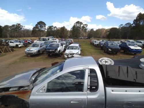 A Tow Truck Is Towing A Car On The Side Of The Road — Old Bar Wreckers In Taree, NSW