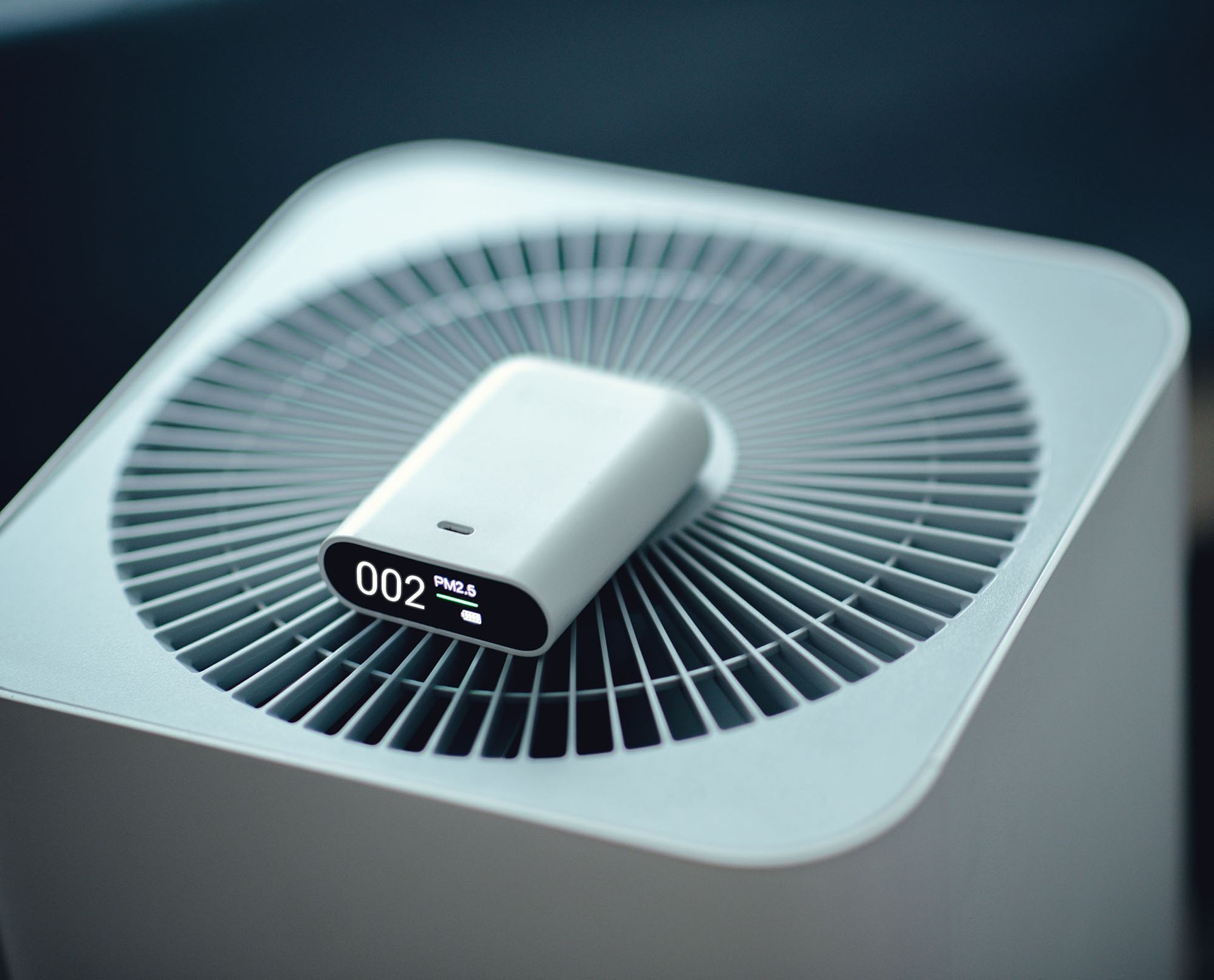White tabletop fan with circular vents and a small digital display on top