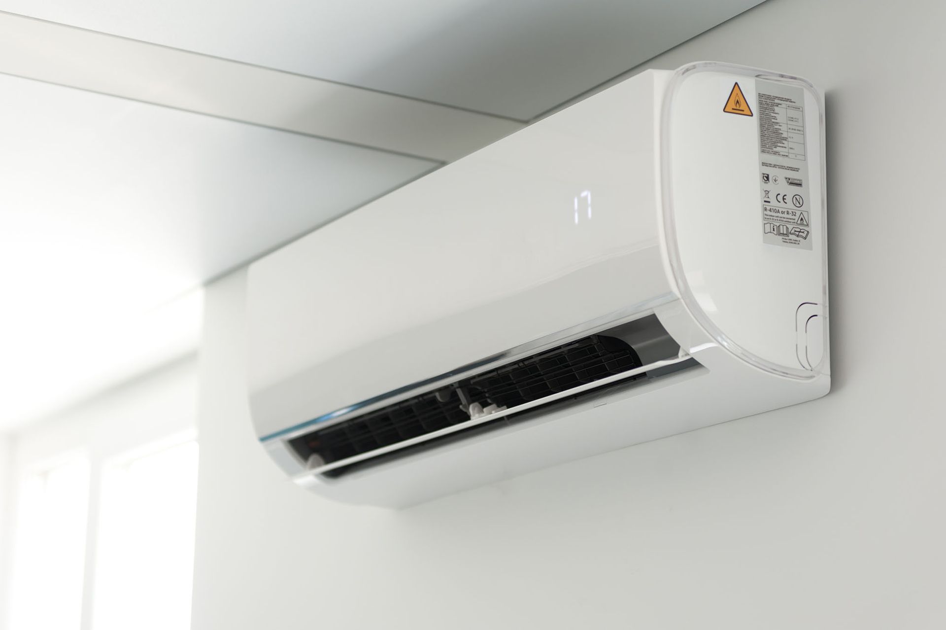 White wall-mounted air conditioner on a plain interior wall
