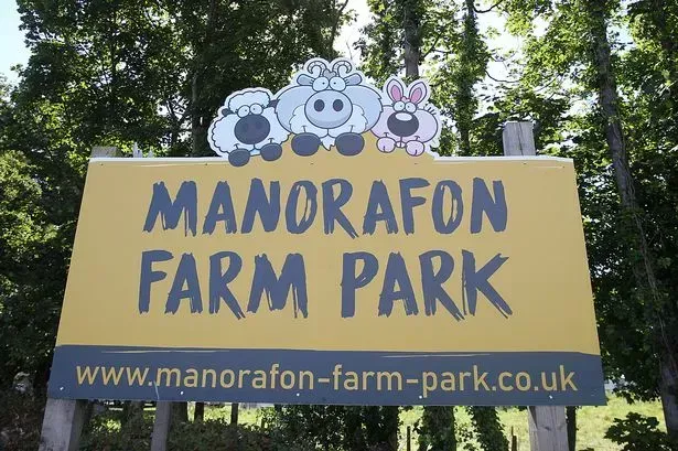 A yellow sign that says manorafon farm park