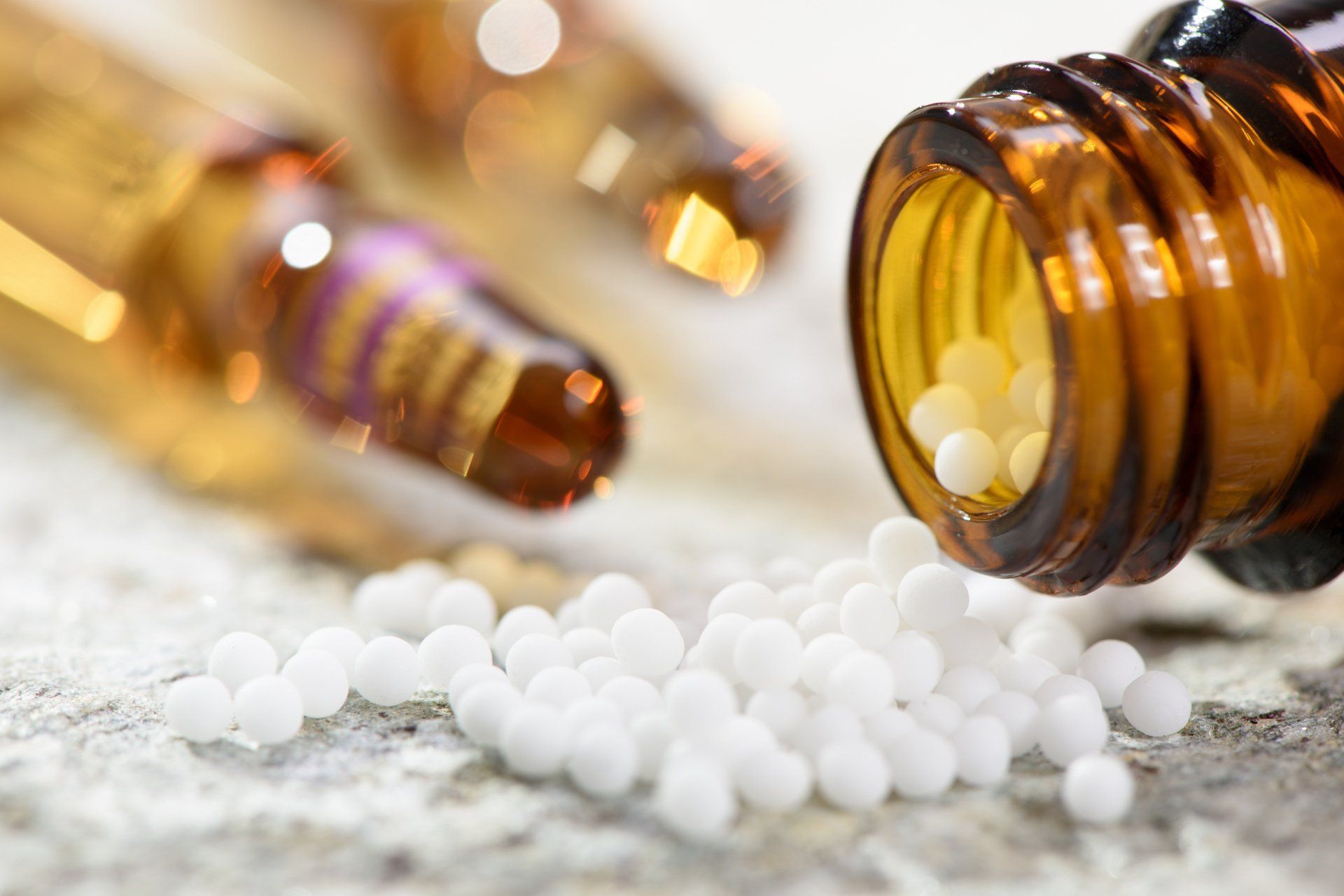 Verschüttete weiße Tabletten neben bernsteinfarbenen Medikamentenfläschchen auf einer Holzoberfläche