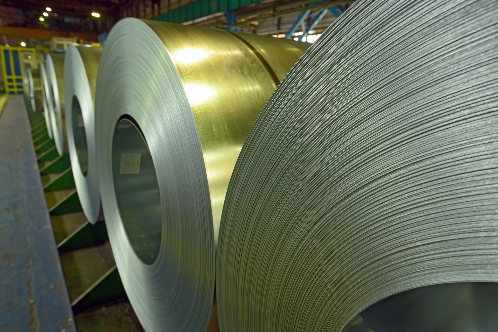 Industrial steel coils stacked in a processing plant for manufacturing applications.