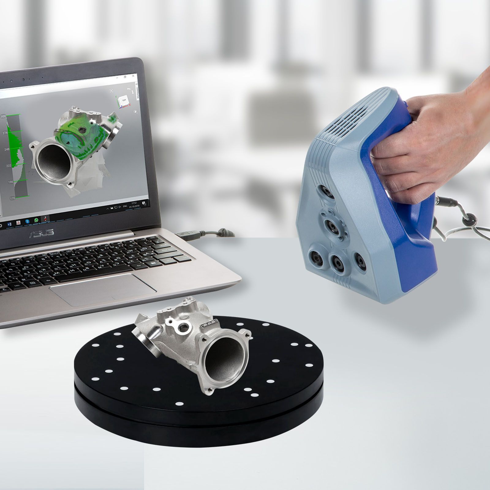 A person is using a 3d scanner next to a laptop