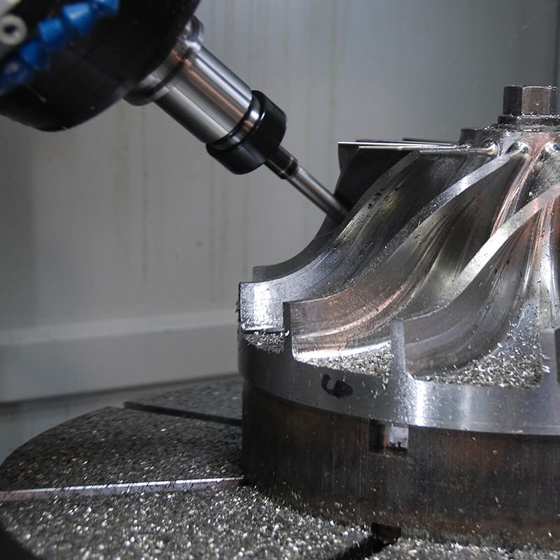 A metal part being created with a multi axis milling machine