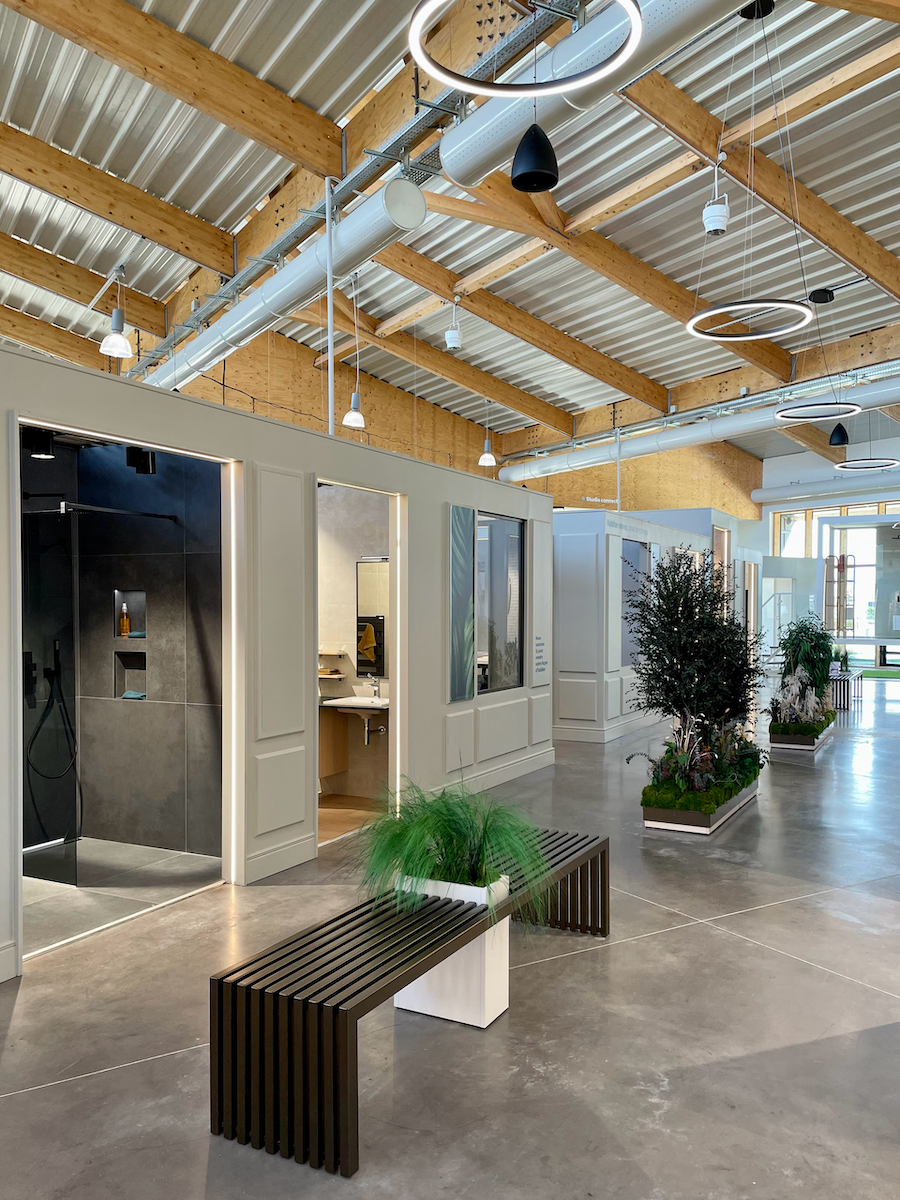 Hall d'entrée moderne avec murs de verre, poutres en bois, bancs et plantes en pot