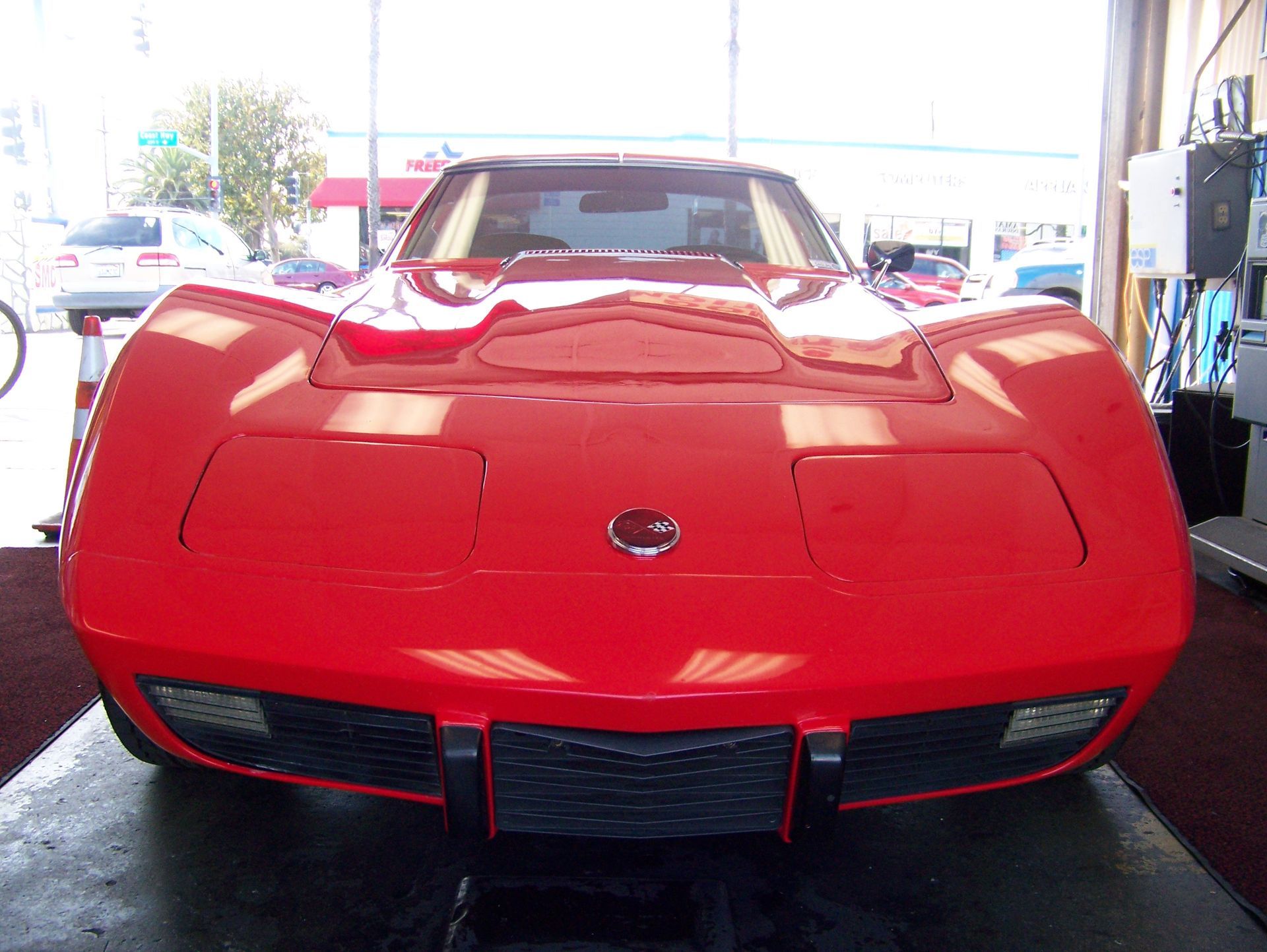 Red sports car viewed from the front in a garage or showroom