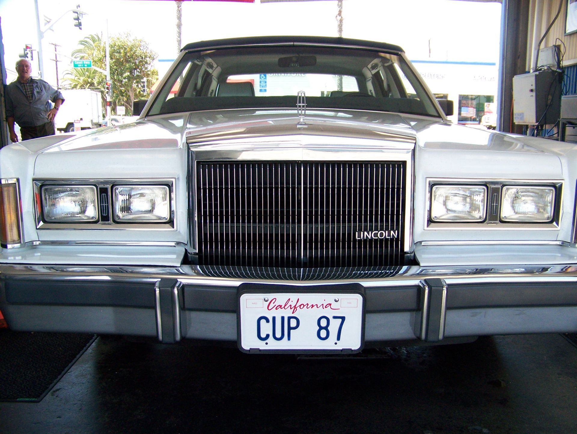 Front view of a silver classic car with a California license plate reading “CUP 87.”