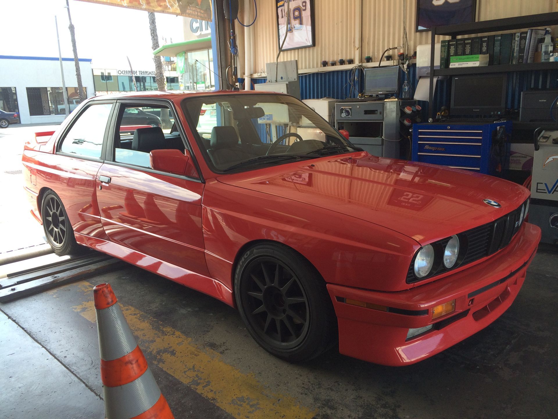 Red sporty coupe in a garage, with a front-mounted intercooler and black wheels