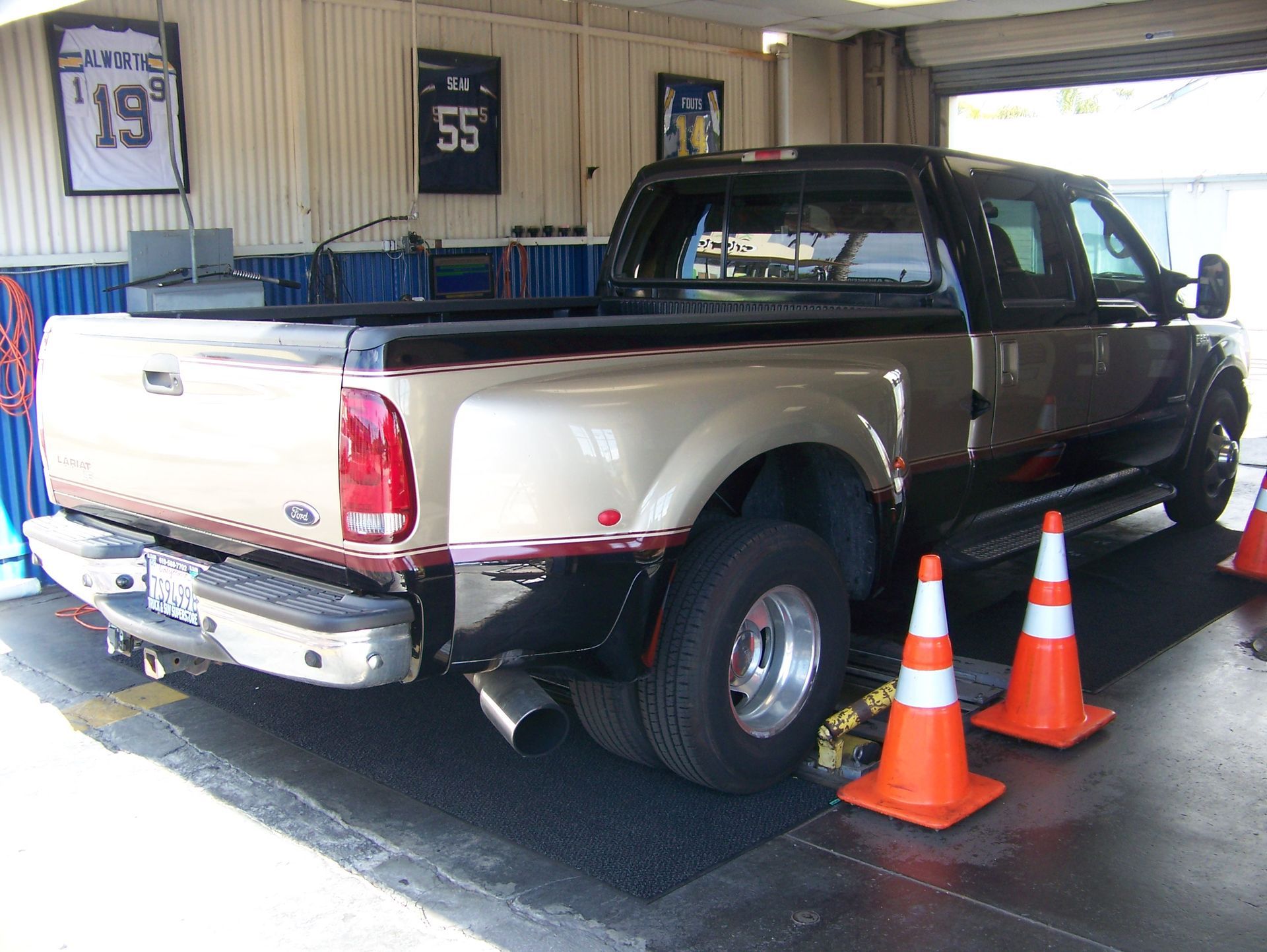 Pickup truck inside a garage, rear view, with orange traffic cones nearby