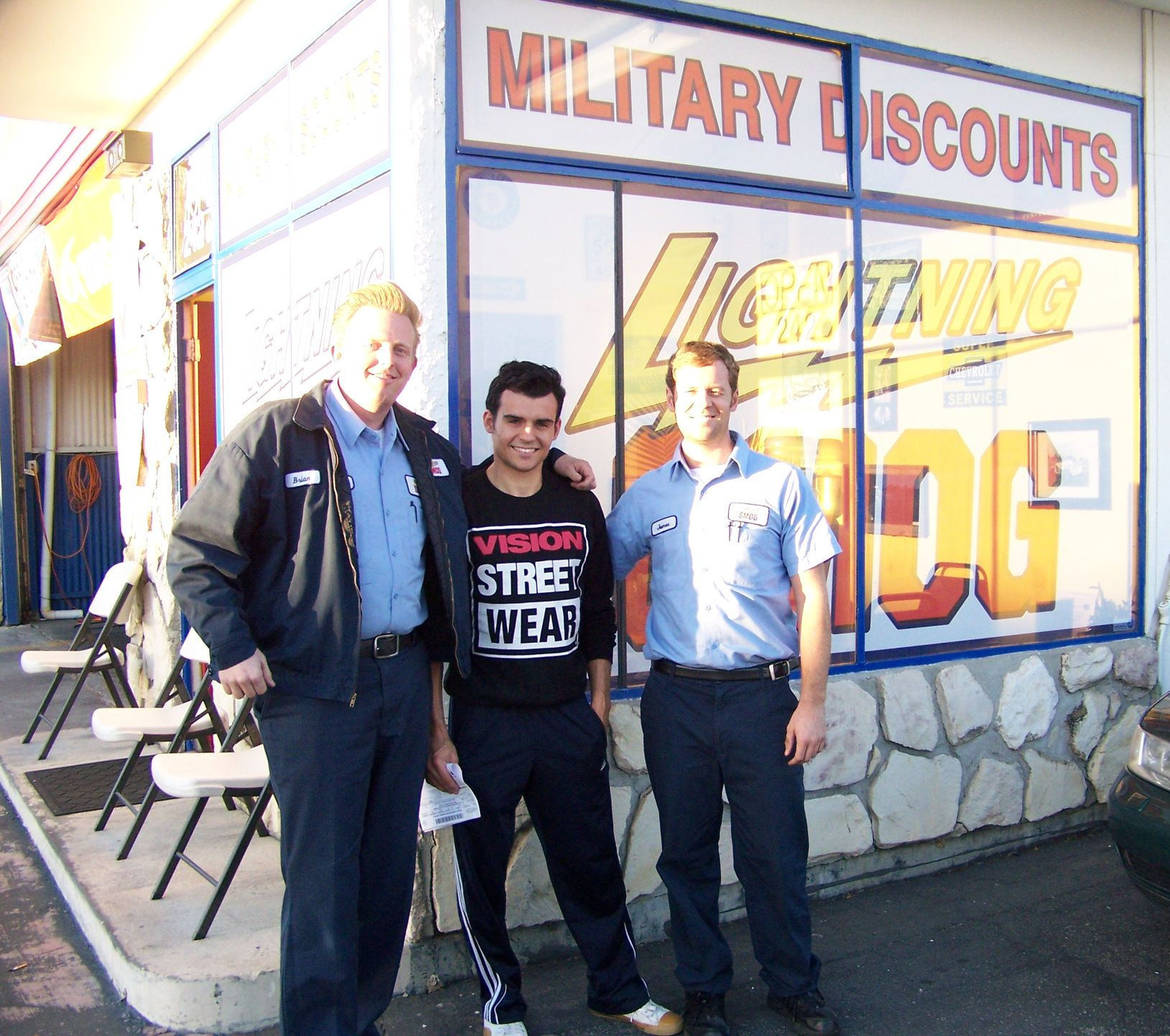 Three men stand outside a storefront with