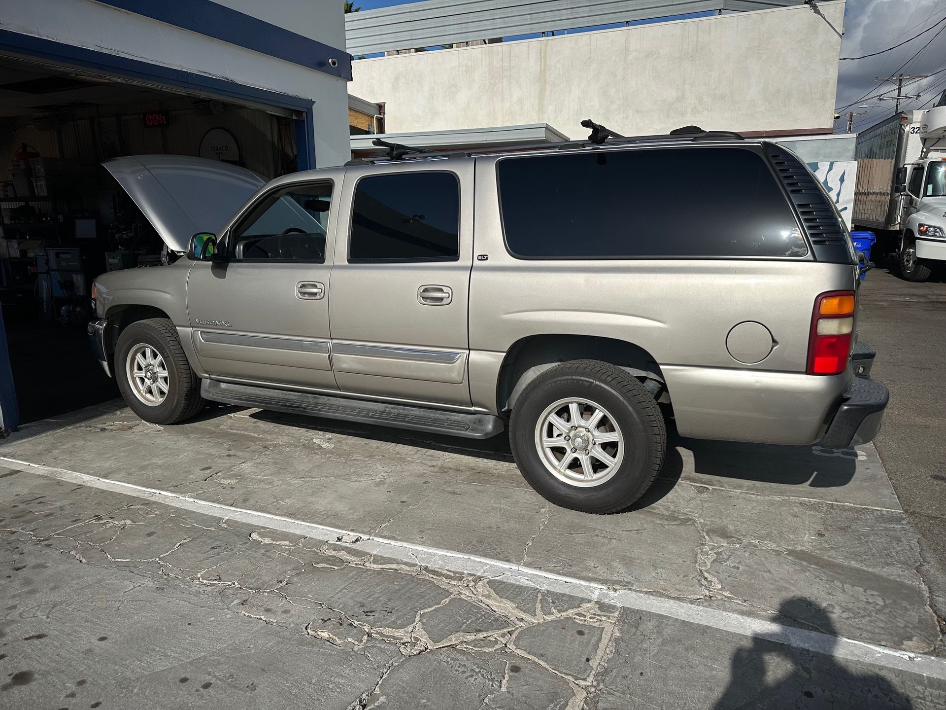 Silver SUV parked beside a building in a sunlit lot