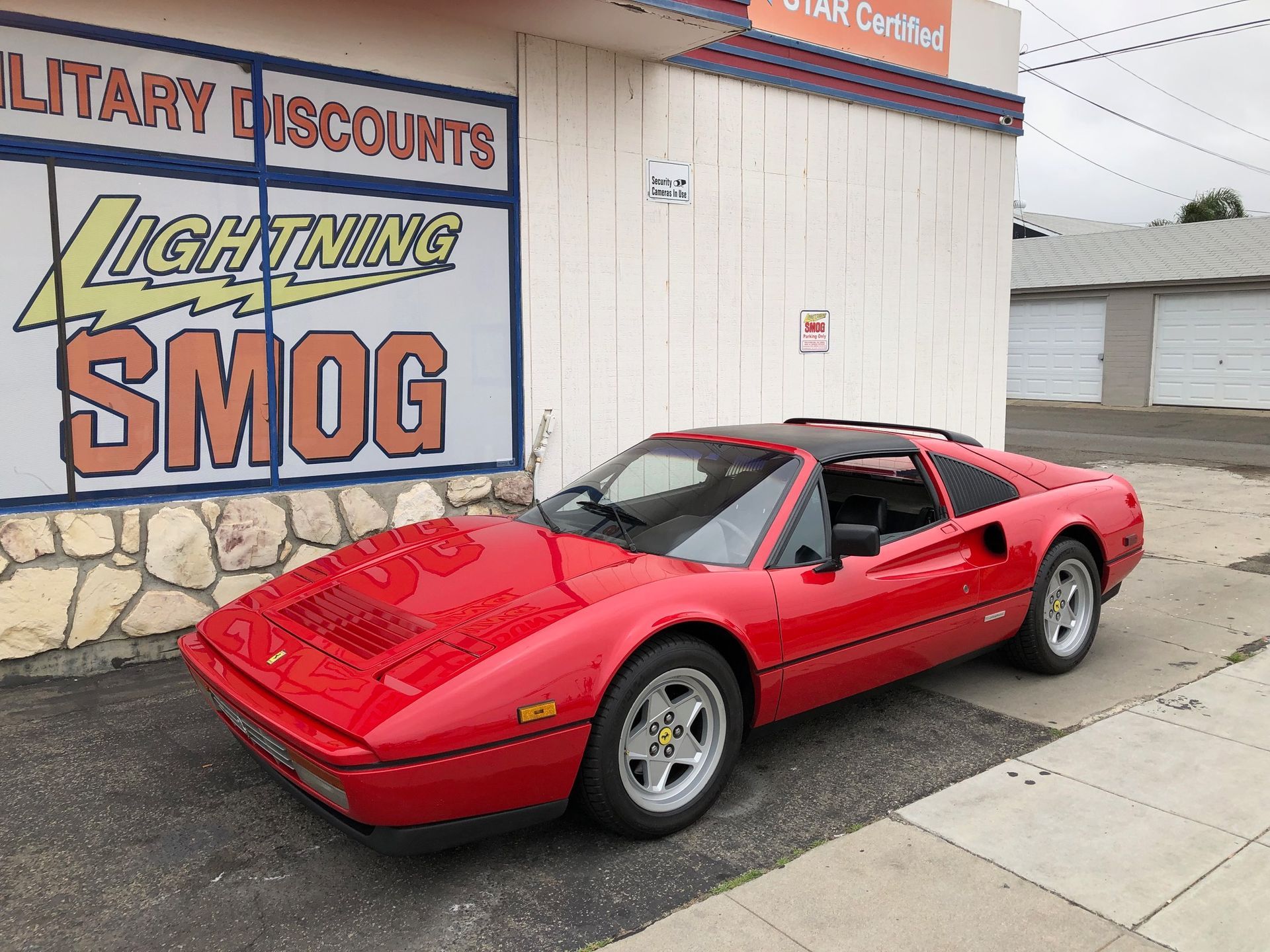 Red sports car parked outside Lightning Smog shop building