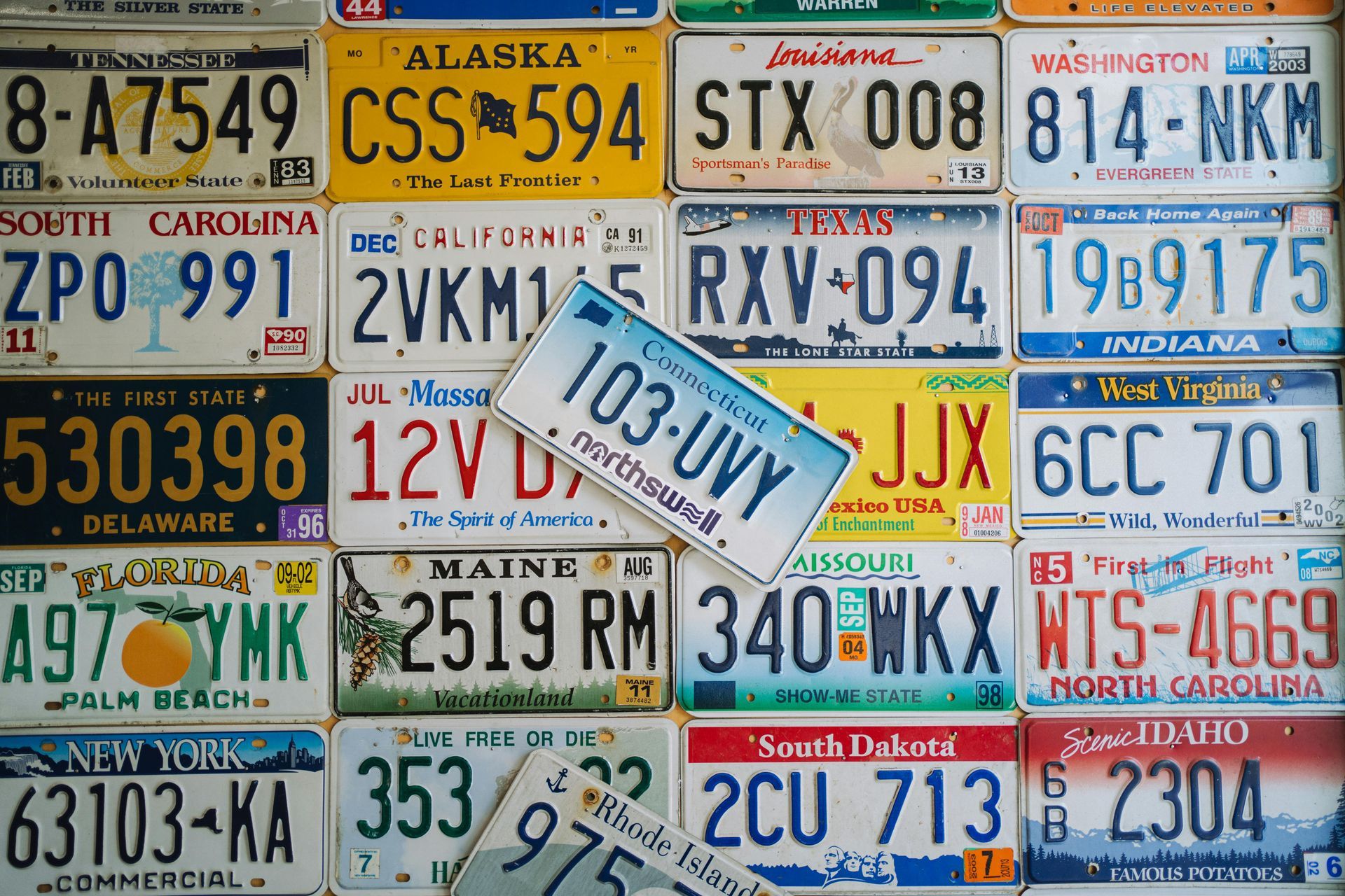Assorted colorful U.S. state license plates arranged in a collage