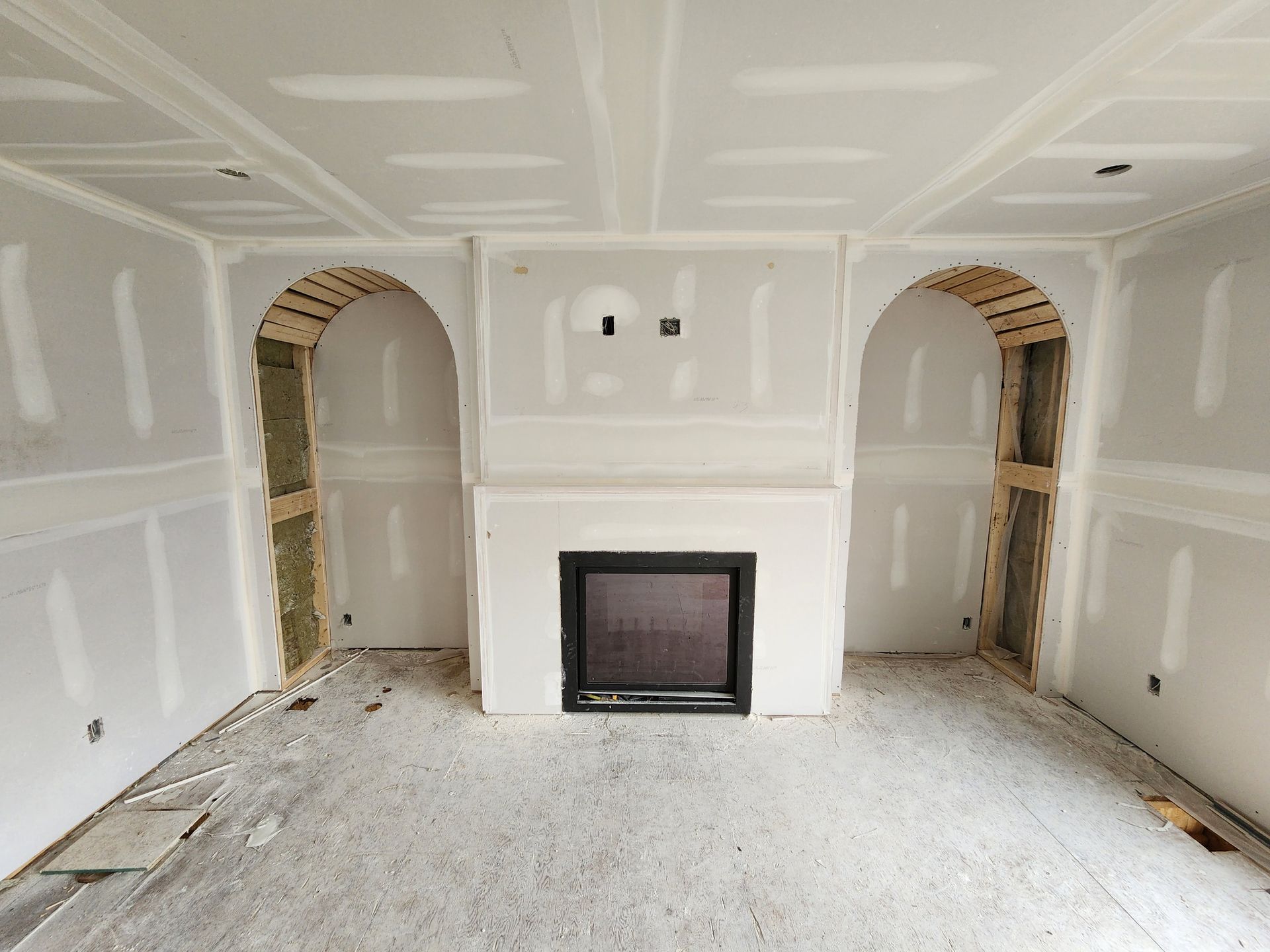 an empty room with a fireplace in the middle of it