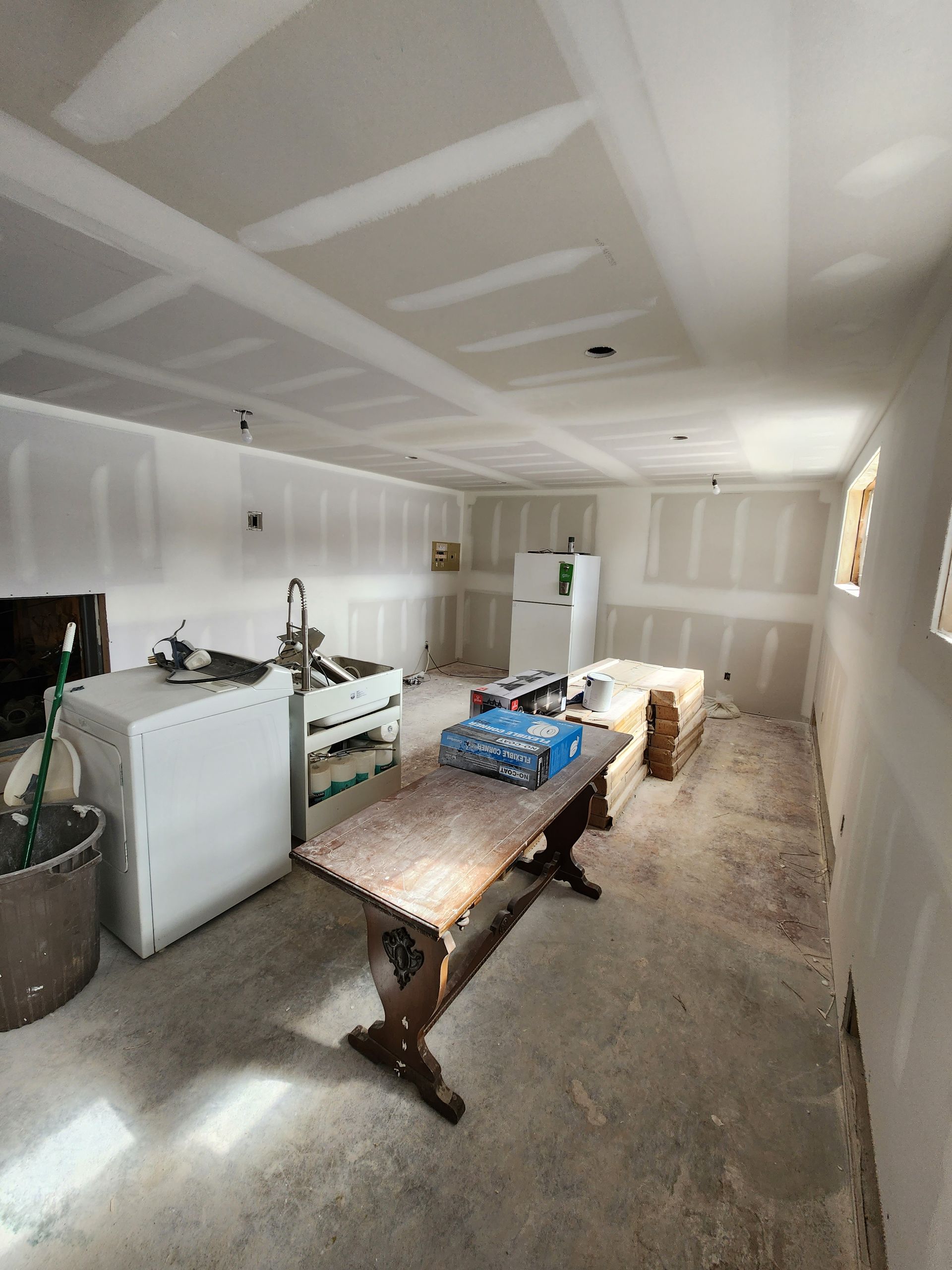 a room with a table and a washer and dryer in it .