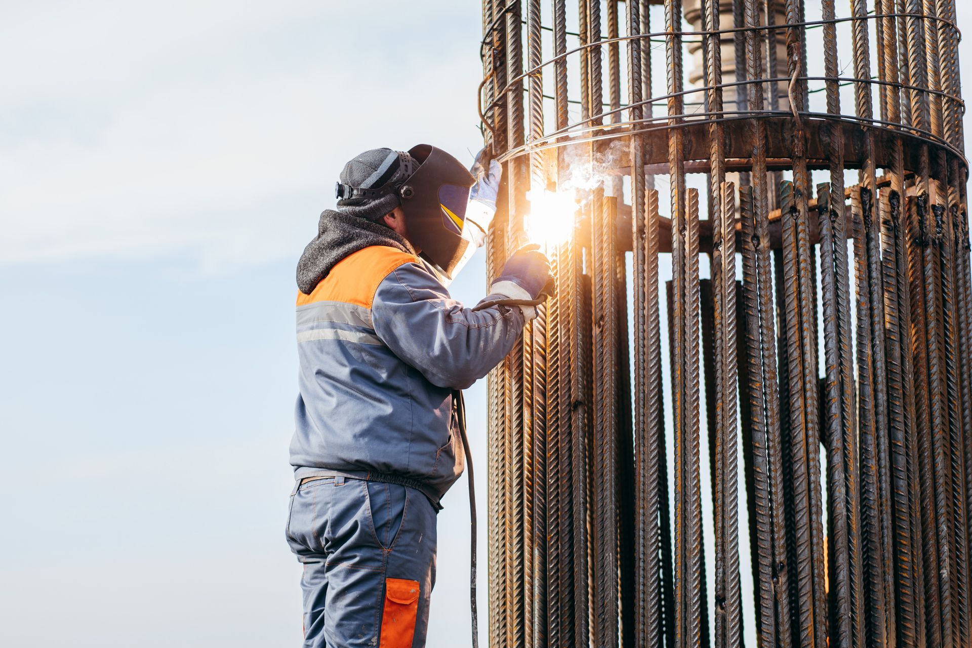 a man is welding a metal structure on a construction site .